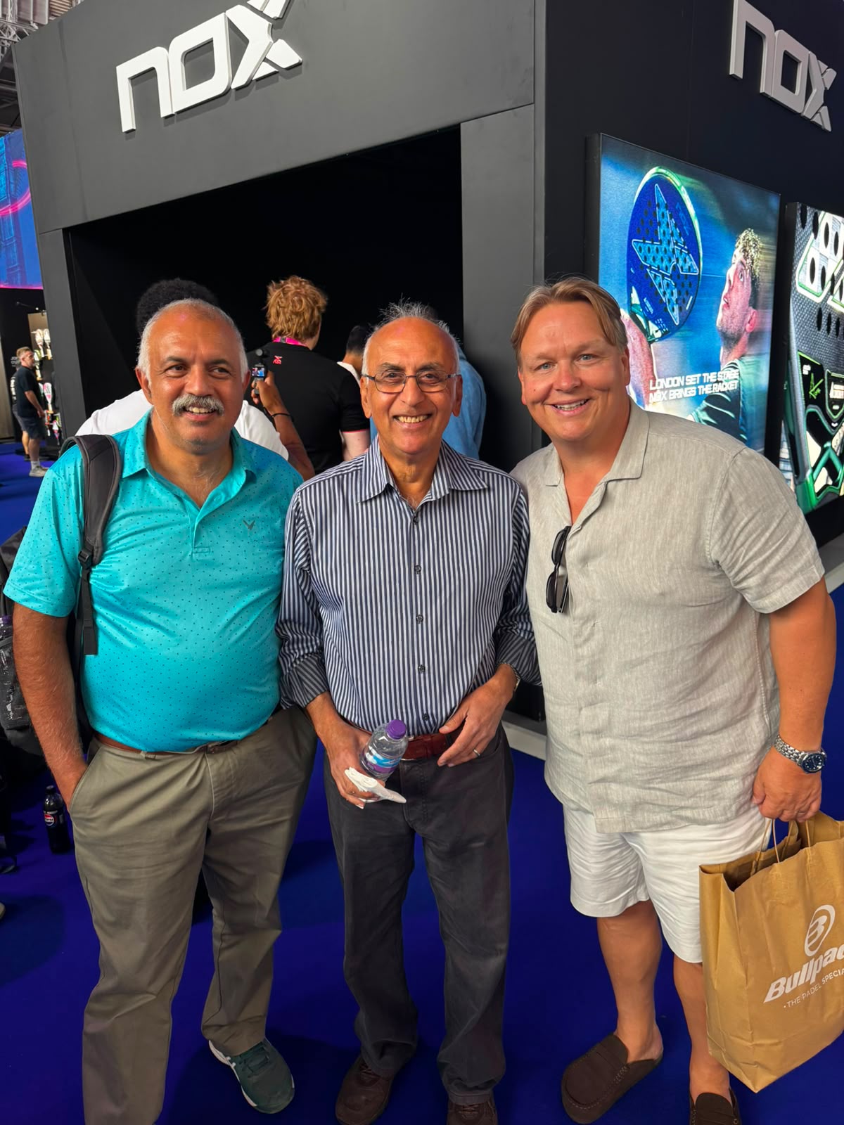 Three padel enthusiasts together inside Olympia during London P1